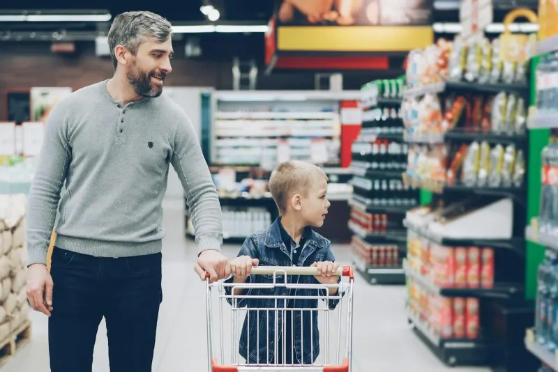 A father and son shopping together in a supermarket