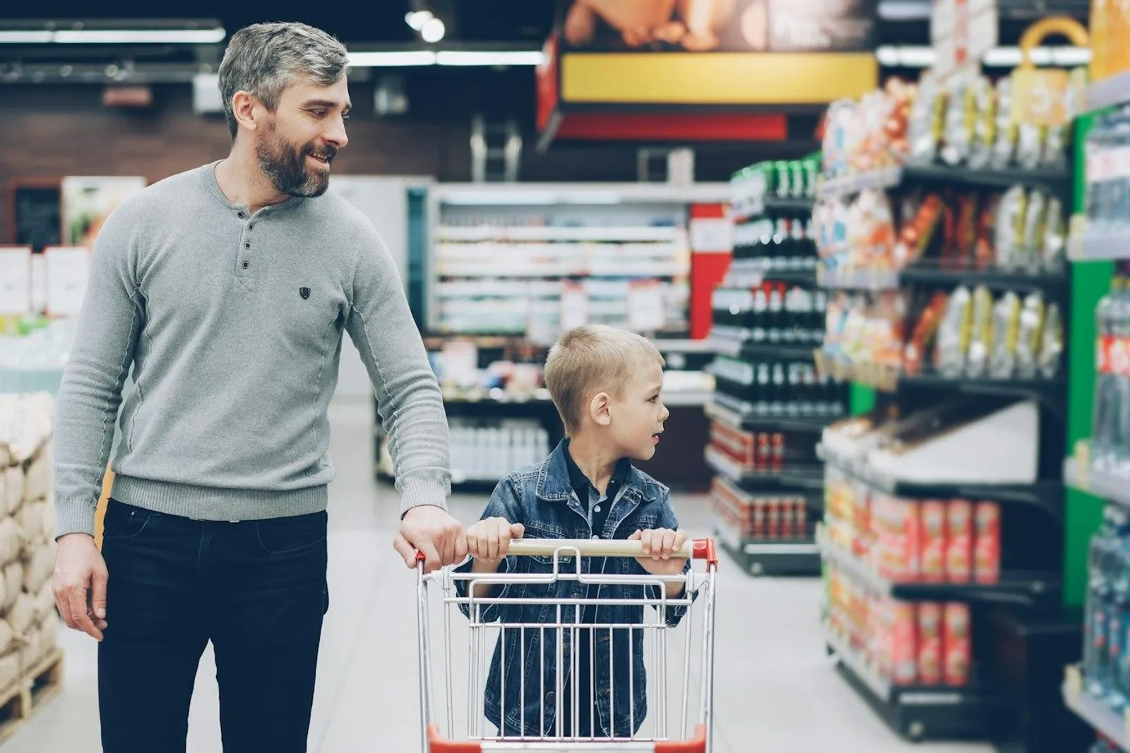 A father and son shopping together in a supermarket