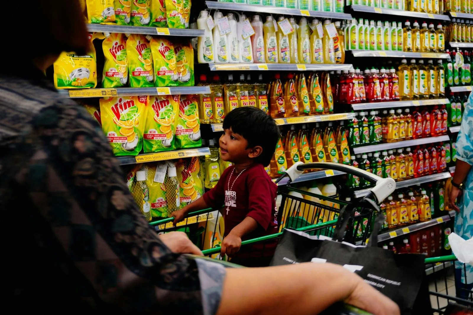 A child in a grocery store aisle looking at products on the shelves