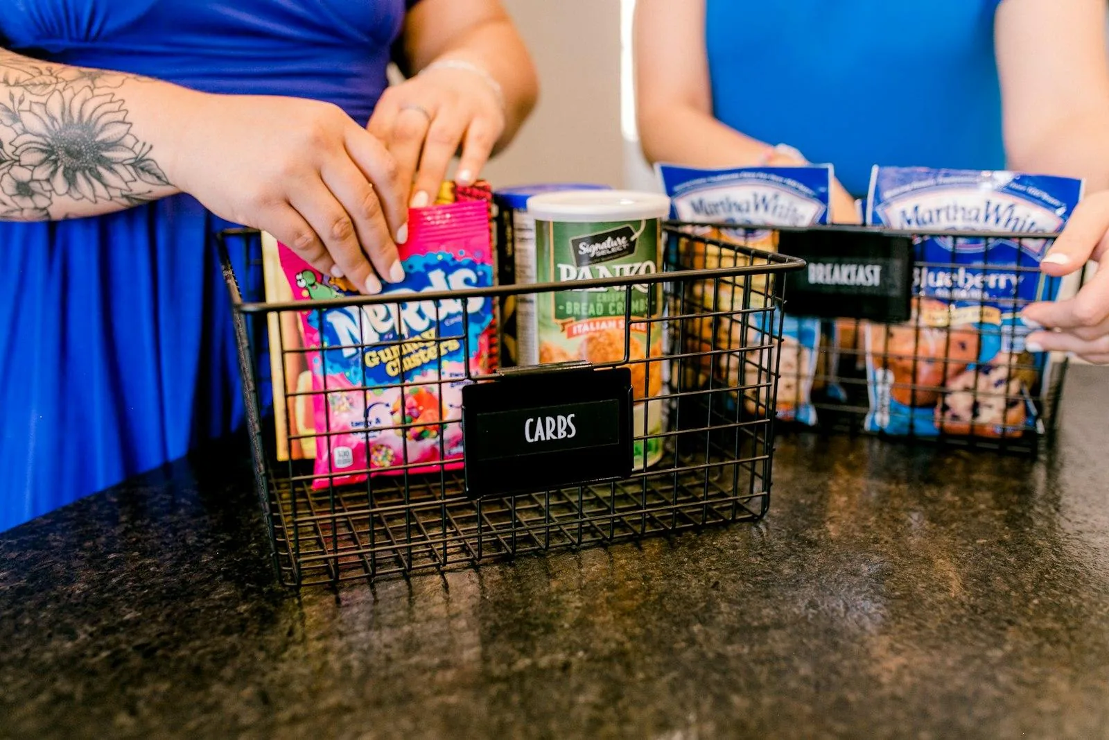 Hands sorting packaged foods into labeled wire baskets
